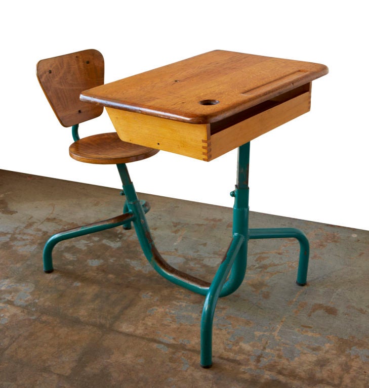 A charming French school desk by Jean Prouvé, with almost zoomorphic lines.  Ideal as a homework station for elementary-school-age children; the seat and the desktop are both easily adjustable for height. Original condition, and a great patina