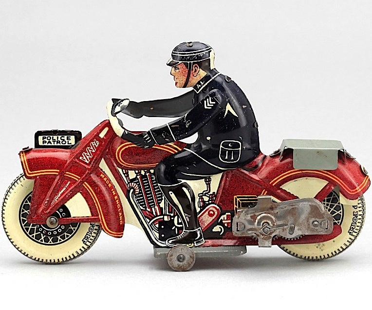 A charming wind-up toy motorcycle, made in the 1930s of tinplate lithographed in red, yellow, blue and white. Lovely condition.