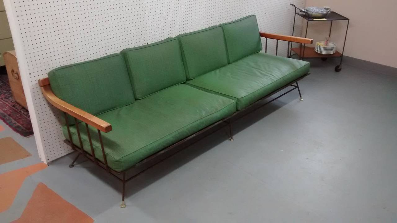 Fantastic Richard McCarthy designed steel and wood sofa, dating to the early 1950's. Heavy duty construction with six cushions, wooden arm and rail structure, and splayed legs with articulated brass end caps. 

Found recently in a mid century