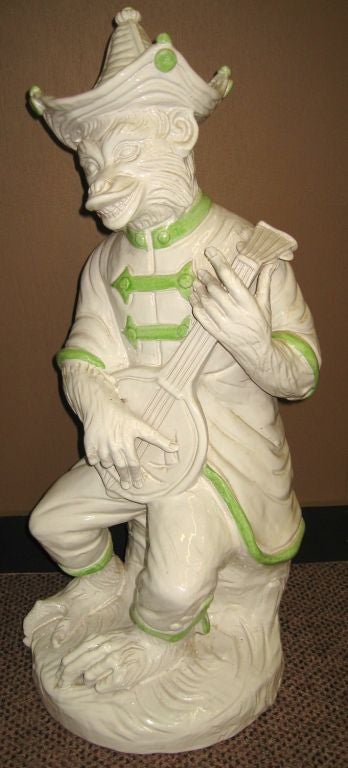 Recently removed from a high-end Palm Beach Florida estate, this pair of white glazed terra cotta monkey musicians date to the late 1950's. Expertly modeled wearing Chinese style tunics and hats, the pair measure an impressive 28