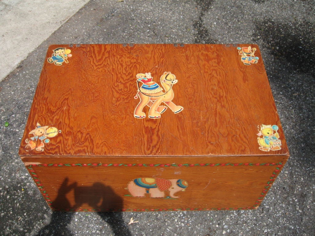 Estate fresh piece, this child's toy chest dates to the late 1930's and is a hand made piece rendered in pine panels using antique hinges and well-done interior joinery. Vintage decals decorate the exterior, while steel rollerball feet allow ease of