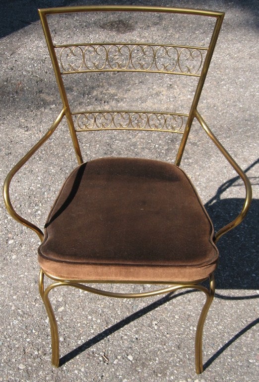 Wonderful and rarely found model Chiavari arm chairs, dating to 1950.  <br />
<br />
Rendered in solid heavy stock brass, weld fitted, resembling lines from a Rene Prou iron chair from the 1940's. <br />
<br />
Elegant curvature speaks for