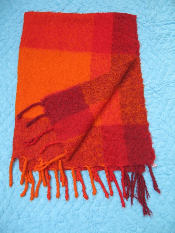 Very rare Lena Rewell signed afghan or throw rendered in 100% wool, hand woven in Finland. Done in hues of hot orange and red with dreadlock fringe.  Original label still present.