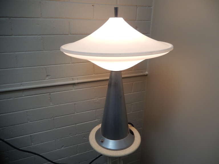 Made for the Contemporary Hotel at Walt Disney World in Orlando, Florida, this lamp is an original fixture made site specific for the hotel.  

Rendered in steel with a perspex/acrylic shade.  

Lead photo shows lamp photo shopped on a beige