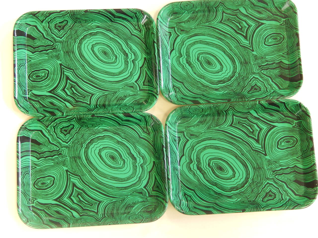 Lovely set of four signed Fornasetti hors d'oeuvres serving trays, dating to the 1960s. 

Rendered in cast and screen printed melamine, these trays are done in a pattern reminiscent of malachite. 

Measure 8