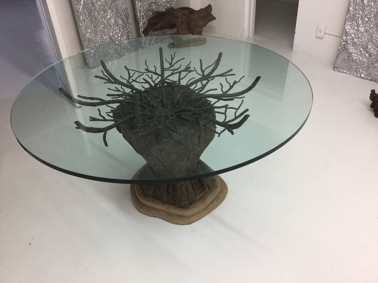 This is a great center or dining table. The tree trunk is encased in a composition base and the branches are metal.