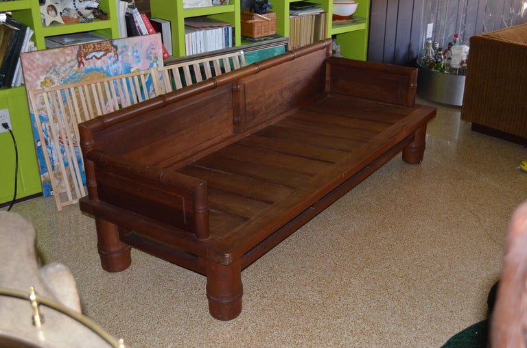 Signed McGuire faux bamboo sofa executed in solid teak. Very interesting design with carved arms and chunky legs. Sofa / bench is shown without its single 4