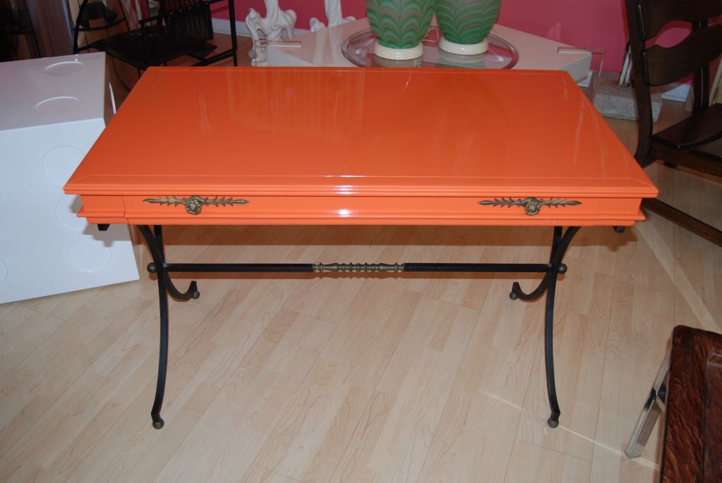 Chic Italian writing desk/vanity and original chair expertly refinished in high gloss Hermes orange.Nice large  center drawer.Wonderful wrought iron bass with brass accents.Great patina.Perfect for floating in any room!