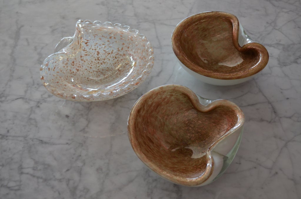 Set of three Murano clam shaped vessels/ashtrays with copper  interiors and white exteriors. The third one is clear with the copper throughout. Copper has a great sparkle! DIMENSIONS FOR THE CLEAR VESSEL IS LISTED BELOW. THE PAIR IS AS FOLLOWS:
