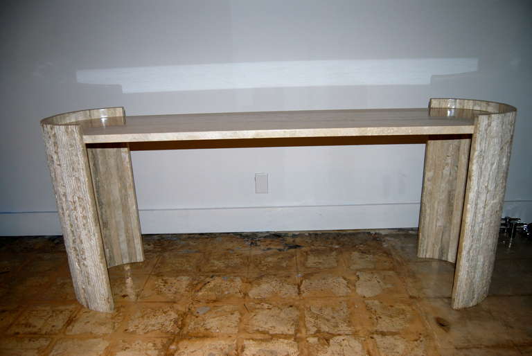 Exceptional !  Italian  travertine console table executed in a juxtaposed polished  top and scored slab sides. Table is in beautiful tones of cream with very light soft gray hues throughout. Perfect against a wall or utilize as a sofa table. For