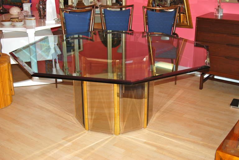 Octagon shaped dining room table executed with a mirror and brass designed table base. Beautiful rich tones to base. Table has its original octagon beveled top as shown. Comfortably seats eight.