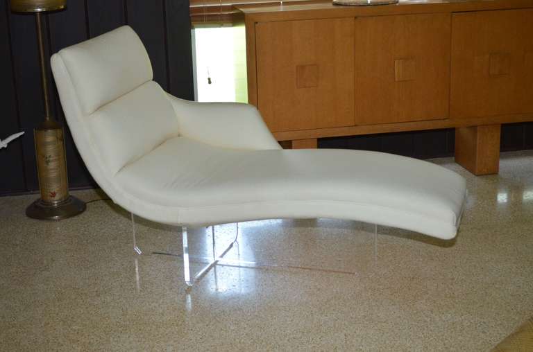 Stunning Vladimir Kagan Erica chaise longue, Model-6910L. Chaise is designed with a single contoured arm, fully upholstered in a cream tone fabric and accented with a cruciform clear lucite base. Ideal for floating in a room. Extremely comfortable.