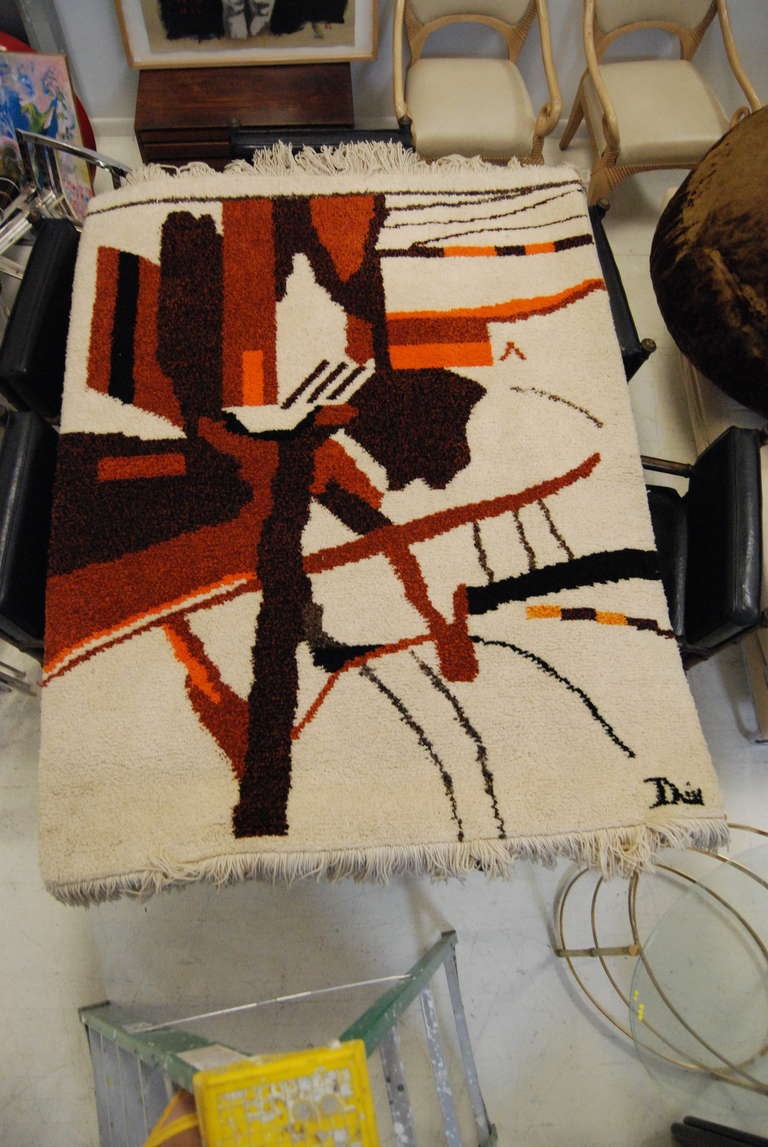 Excellent! Signed 1960's mid century rug executed in 100% wool. Rug has a wonderful abstract design and woven in beautiful  tones of browns,oranges and beige. Rug is in pristine condition as it has hung on the wall as a tapestry since the 1960's.