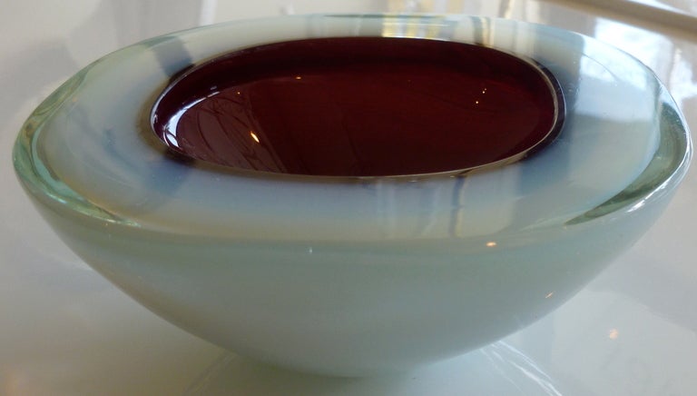 This luscious Italian glass geode bowl by seguso has white to opalescent layers of glass on the outside and cranberry red interior.