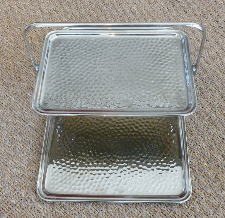 This early period stepped hand hammered silverplate serving tray from the 20's folds up like a clutch bag.... clever...
It has been polished and has a signature of Leo Schlesinger Co.Inc. NY. with a patent #...the camera cannot pick this up;