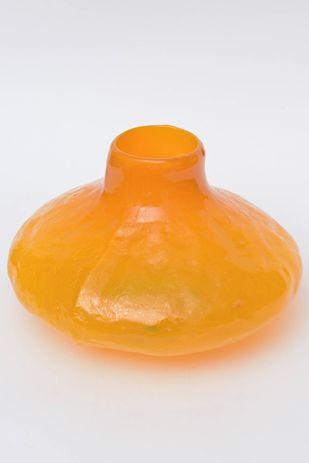 This large tangerine orange Blenko vessel or vase is very arresting and rare.
The glass is textured and pebbled, unusual color and shape. It has a gourd shape. Not too many of these around. This was a color from the 1960s.
This particular vase or
