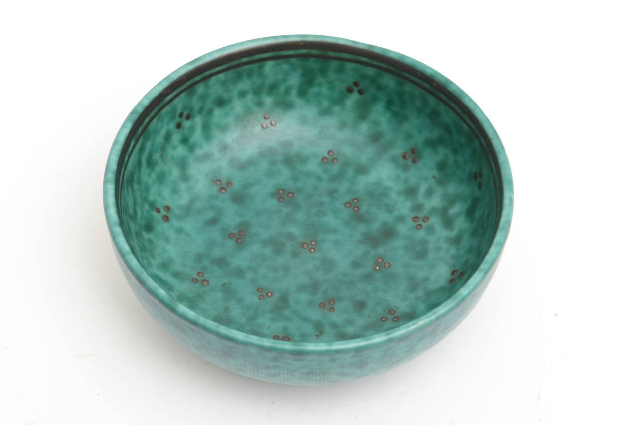 The beautiful color of the notorious green turquoise of the hallmarked Gustavsberg 
Argenta line has small clusters of sterling silver set of 3 dots clustered together all over the bowl. There are 2 inner perimeter lines of sterling silver.
This