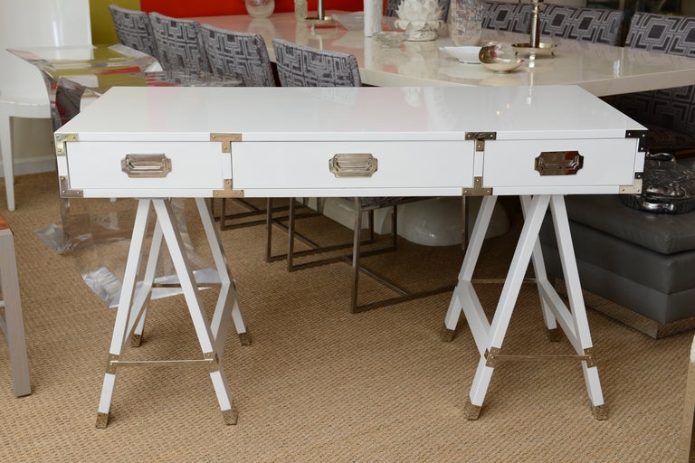 This wonderful white lacquered campaign desk has all nickel silver
appointments of great original hardware. it sits on grooves of the sawhorse legs. It is sleek and handsome!