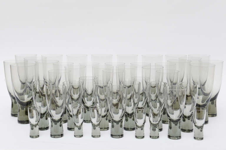 Four sizes comprise up this collection of 45 period Danish pieces of timeless stemware.
The color of the  glasses are  graduated from clear to smokey green to smokey grey; depending on the light.
Moderne, heavy and stunning. These are hard to come