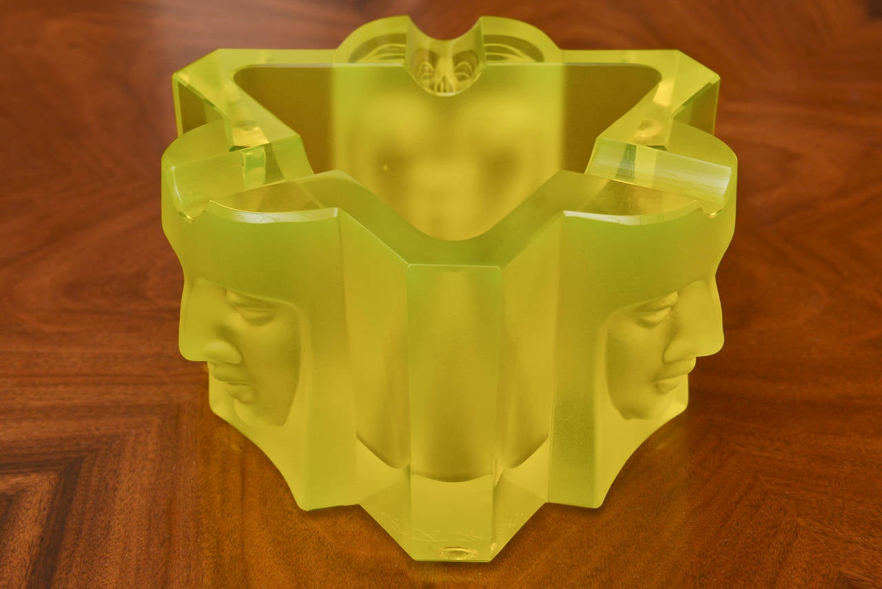 The glass is luminescent, the color is stunning, it is yellow meets chartreuse.
It glows in light and color and energy and shape.
The three faces in molded form act as an appendage outside of the shape of the triangle.
It has three indentations