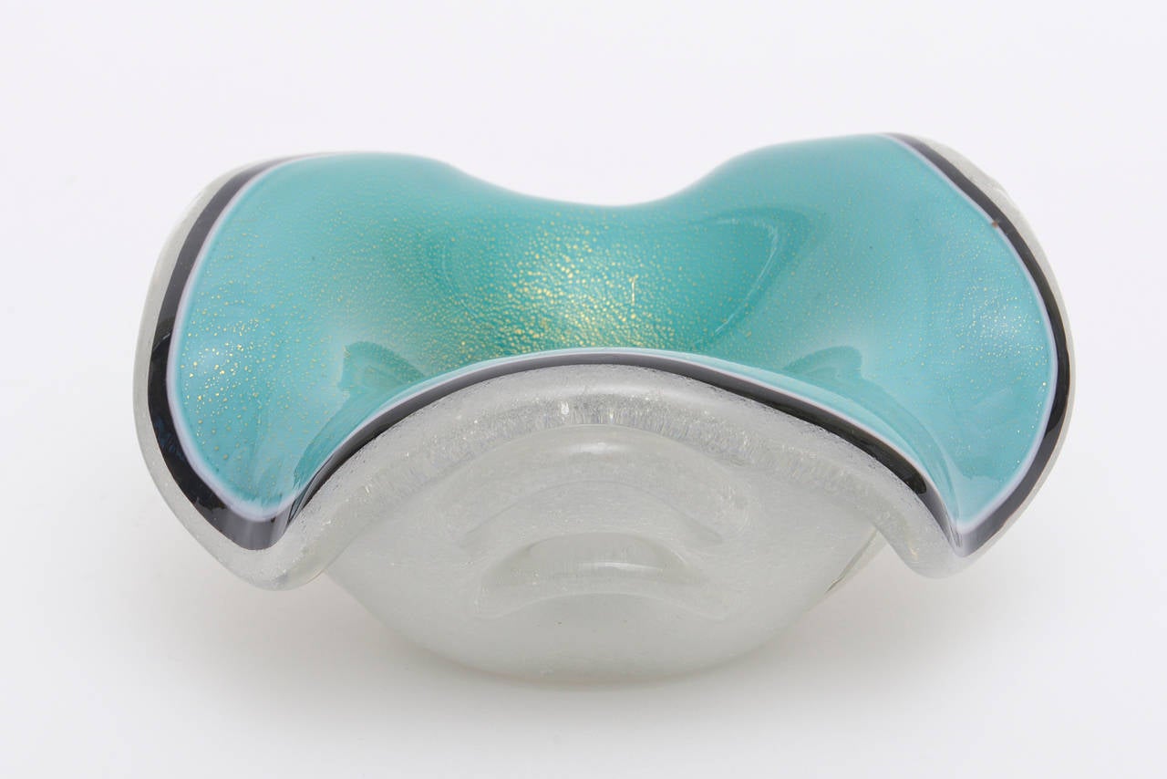 This beautiful and special rare Italian vintage Murano glass bowl has it all going on. It is the work of Seguso. It has several different techniques in one; one is the Pulegoso. The luscious color of the turquoise meets a beautiful swirl of rich