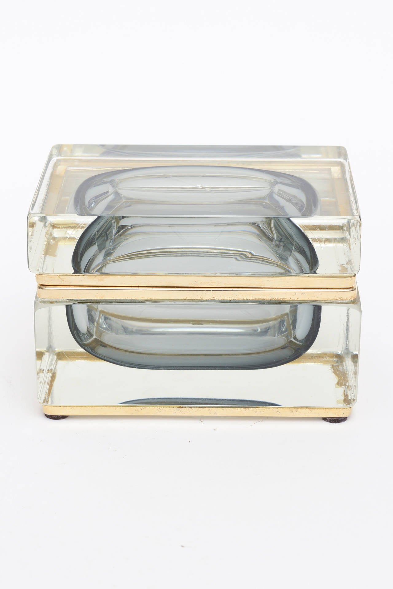 The beautiful colors of the Sommerso from gray blue to smokey gray make this hinged Italian Murano box with all kinds of hallmarks a lovely vessel for jewelry or just as is a glass box.

It is 24-carat gold plated as exemplified on the sides. and