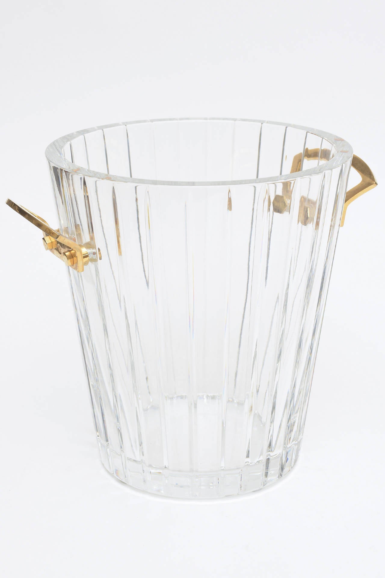 Classic, beautiful, elegant and timeless comes to mind when describing this heavy signed Baccarat crystal ice bucket or champagne chiller.
The sculptural heavy gilded bronze handles on either side add to the beauty of this classic piece. It has