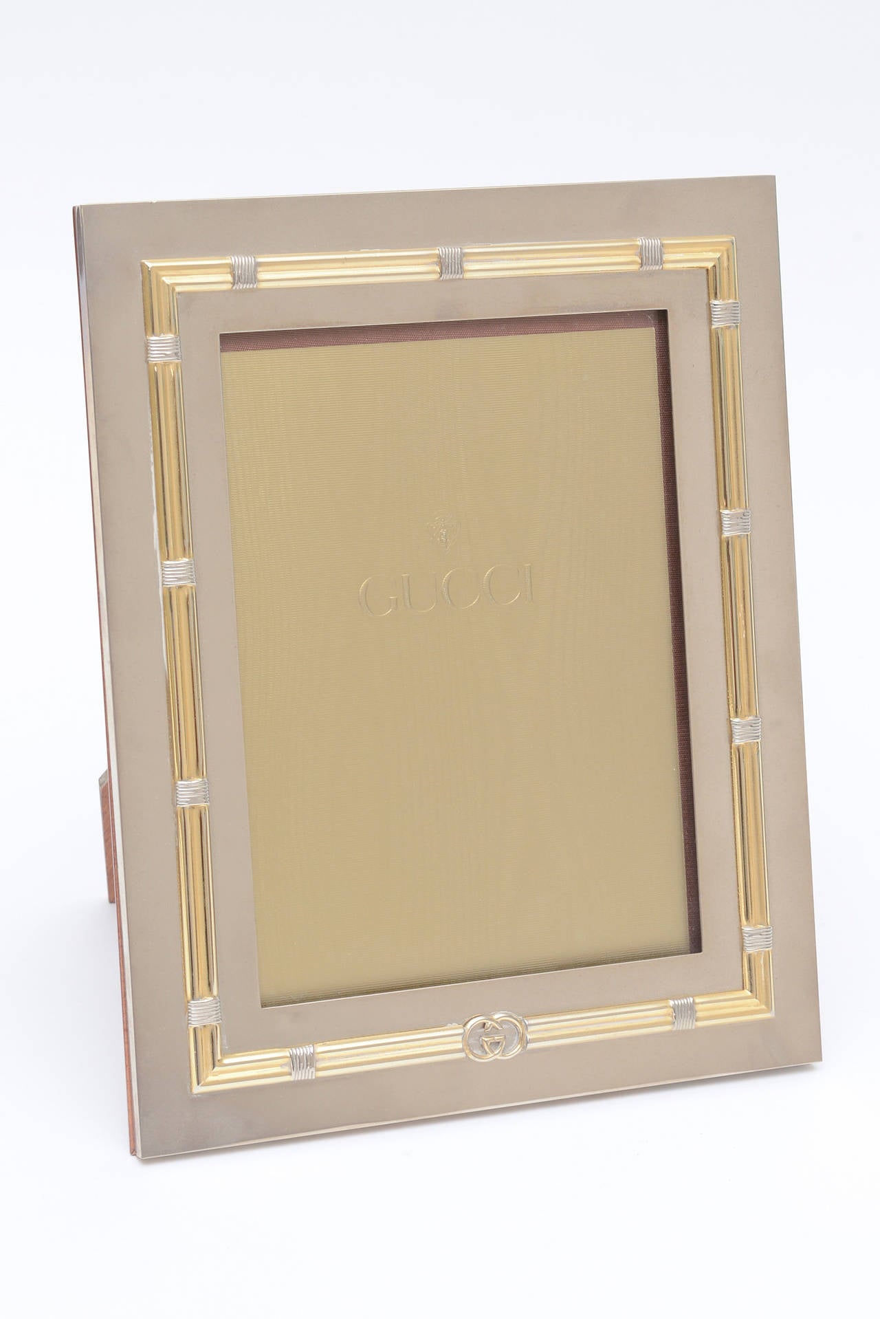 This iconic Gucci logo picture large picture frame has the walnut and rosewood backing. Dual toned.
The mix of metals adds to the versatility of this lovely picture frame.
The GG logo is at the bottom.
The ribbed banding adorns all sides, top and