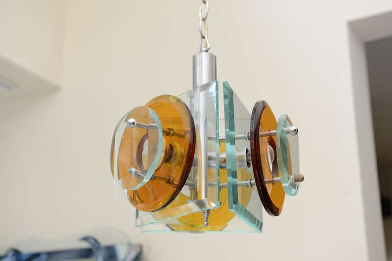 The colors of amber and sea turquoise glass disks are connected with chrome fasteners in this most stunning Italian glass sculptural vintage Fontana Arte pendant chandelier. This is Classic, timeless and a truly beautiful chandelier. There are four