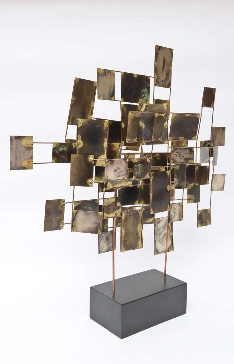 This is a wonderful tabletop Curtis Jere sculpture ... all the mixed metal array of
shapes in squares and rectangles are in abstract formation on brass posts...
the metals vary... as do the surfaces.
The base is black wood...

signed and early.