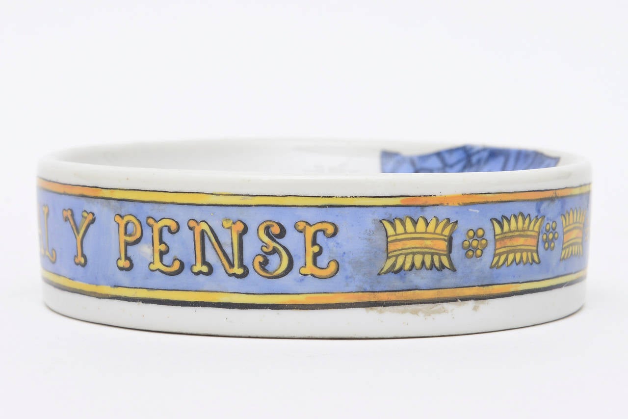 This bowl or dish by Piero Fornasetti and is of the period. It is all in Italian with a warrior crest outlined with a banner buckle. The buckle all in the language goes around the perimeter. This is most likely an unusual rarely seen bowl. It id