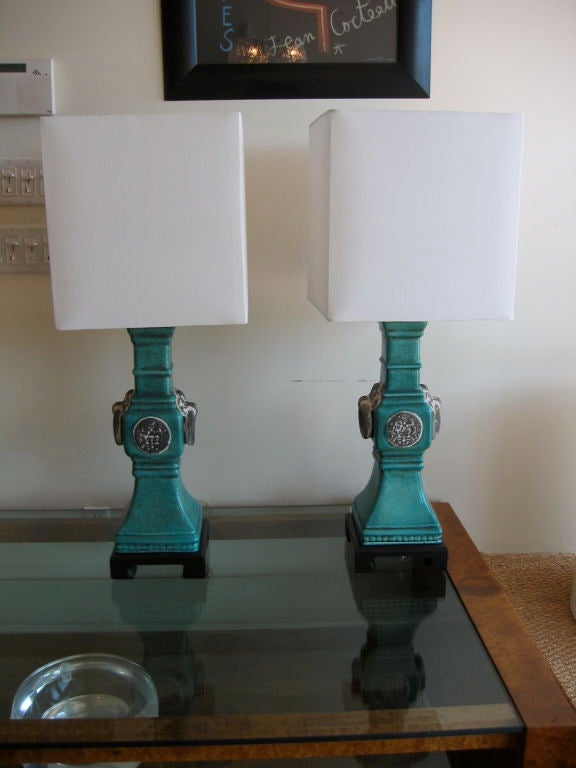 Large scale and impressive lamps fashioned in turquoise ceramic with large ceramic rings and ceramic medallions adorning each side. Newly rewired with 

nickel silvered fittings. Mounted on black wood chinoiserie bases. Square shades are not