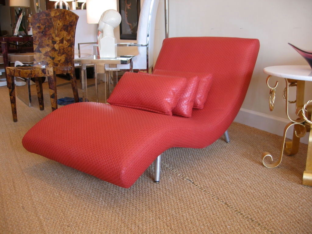 This Mid-Century Modern chaise lounge was re-upholstered in red woven leatherette it has nickel silver steel legs. Very comfortable. Comes with three bolsters. It is vintage and is curvaceous and sits low to the ground. Very comfortable. This is