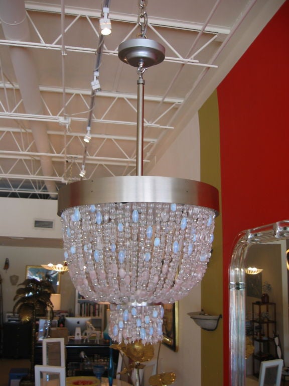 Two tier chandelier consisting of multi strands of clear, pale powder blue, and pale pink crystal, rose quartz, rock crystal, and czech beads. Small silver beads are mixed into the strands which adds an additional sparkle. Stainless steel framing