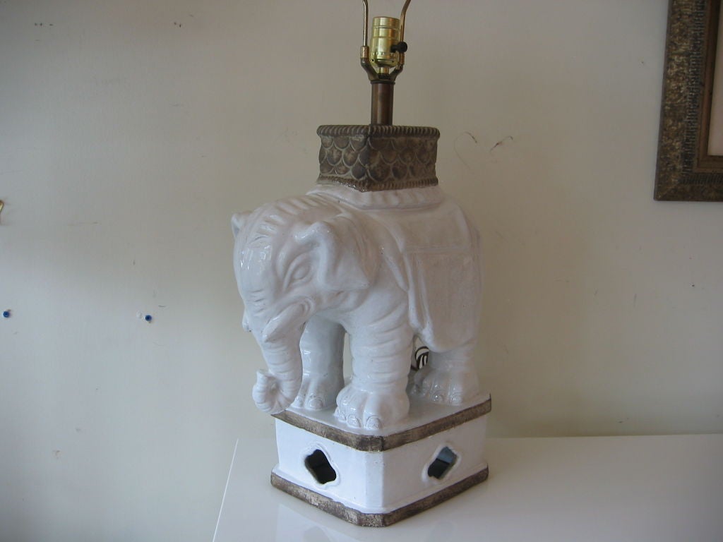 Wonderful good luck elephant lamp with great details. Unglazed portions of base resemble bands of bronze; same technique used on top piece with a scalloped layered design. Bring the wild into your home and the good luck follows.