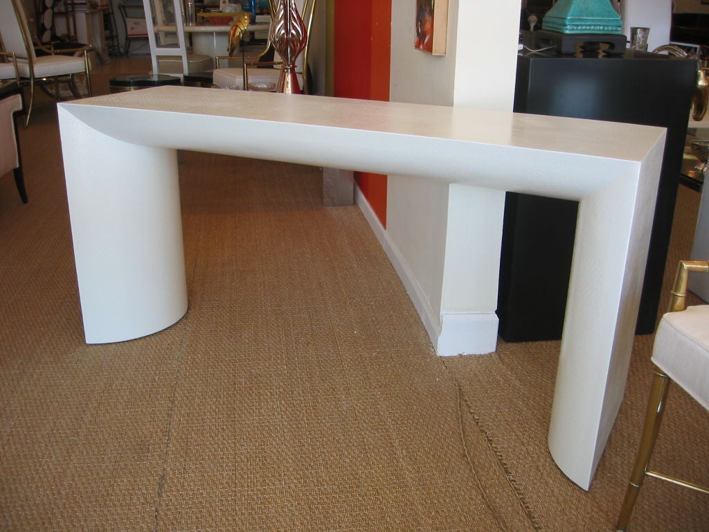 Wonderful linen wrapped console finished in high gloss white. Rounded interior legs and and under top with flat outsides and top. The texture of the linen gently shows through the lacquer. Perfect for an entrance, behind a sofa, in front of a