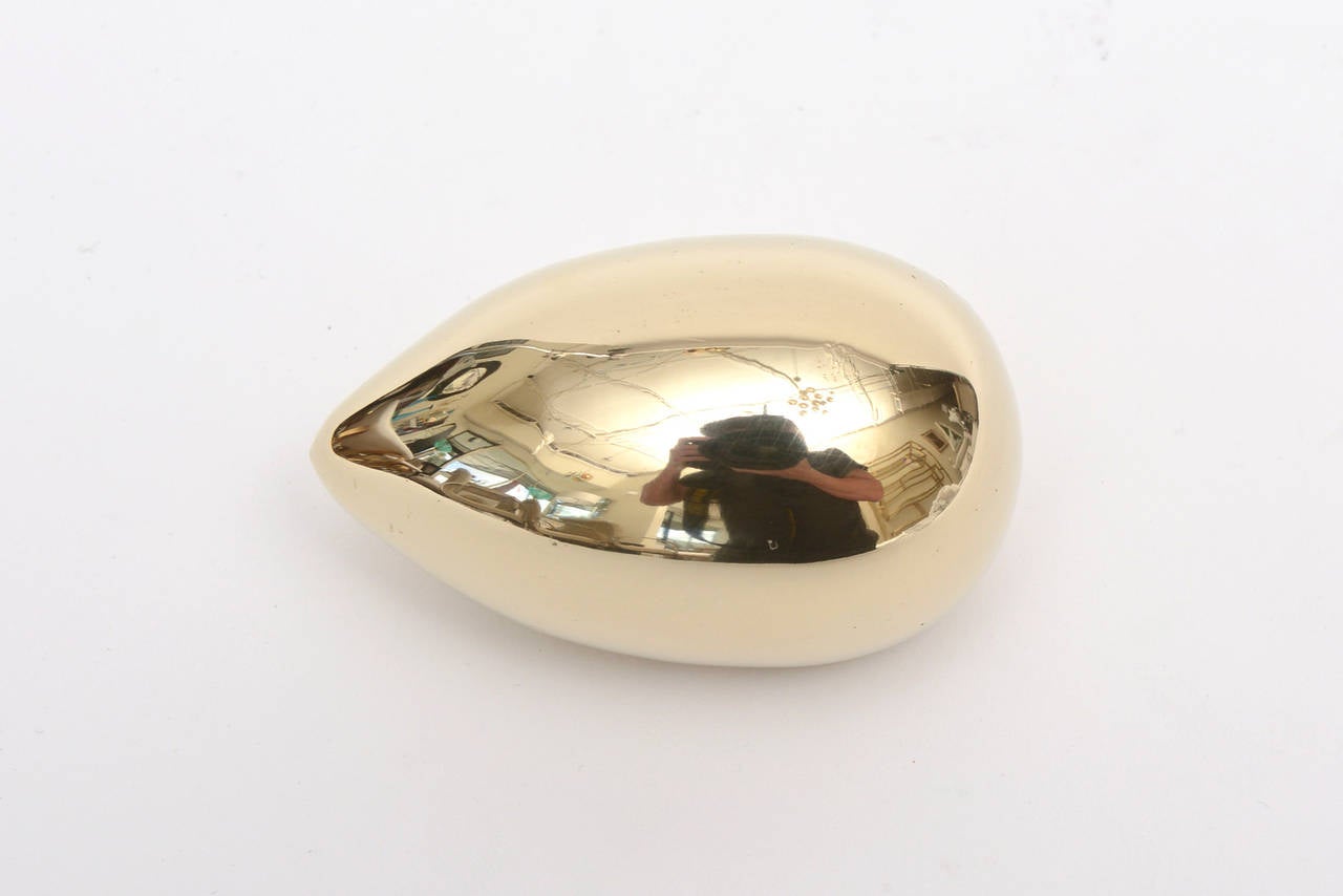 This wonderful polished small brass paperweight/object in the shape of an egg/ horizontal ovoid is by Carl Aubock.
It has great weight to it and sculptural presence.
Fabulous for a desk... masculine and feminine!