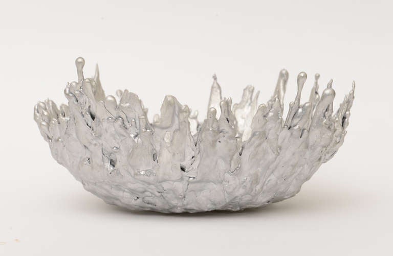This limited edition sculptural bowl made from molten steel toy soldiers was perhaps an anti war Campaign during the Bush era. This is from Alam Moss from NYC and is from 2000.
Looks like globs of silver in castle form. Art meets sculpture.