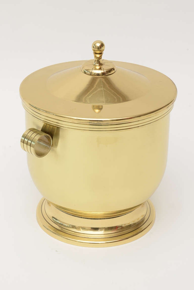 This original Mid-Century Modern Tommi Parzinger polished brass ice bucket with original Pyrex glass liner. It has all the classical lines of Tommi Parzinger. It is from the 1950s. This is timeless!
