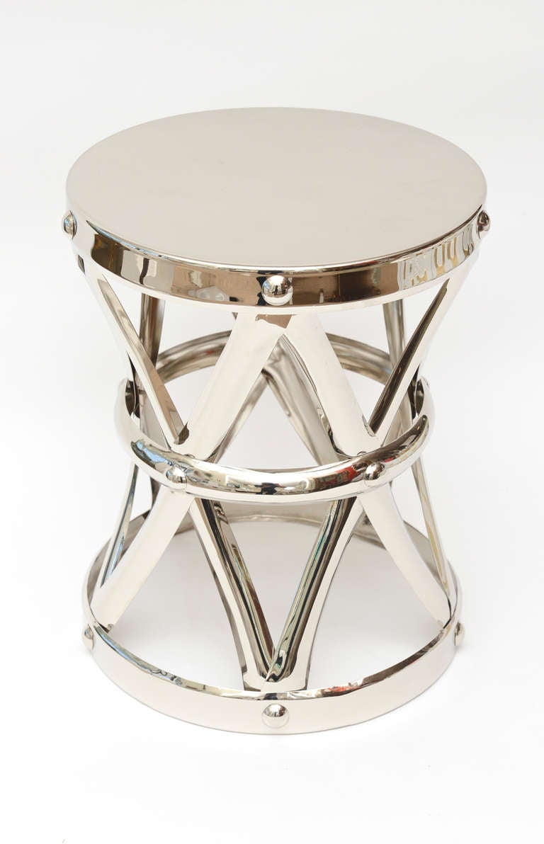 This hand-hammered period stool and or small side table was once abut 10 years ago  nickeled silver over the original brass. It has criss cross straps on this X-stool. This versatile side table and small table can go anywhere; for instance as an