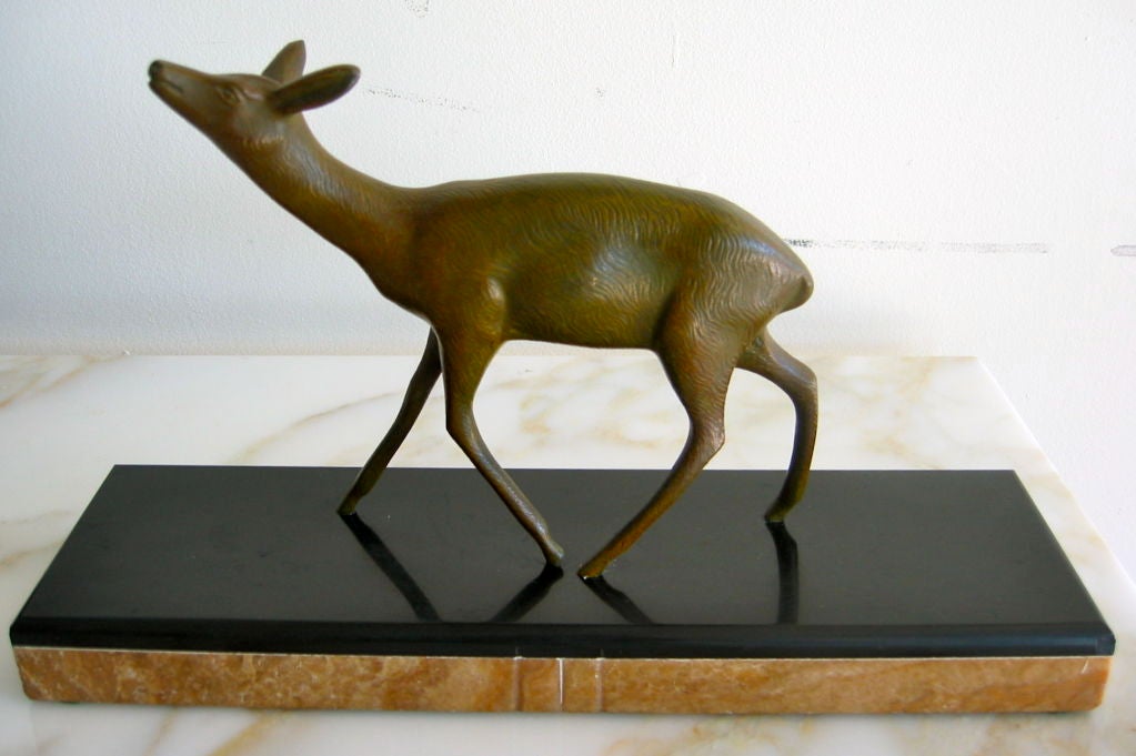 This whimsical cast bronze fawn desk sculpture stands on a substantial stacked stone base.   This is a very heavy piece that has been signed 