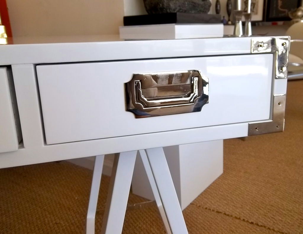 This fabulous campaign desk features a sawhorse base with nickeled silver hardware.  It is finished on all sides which allows this piece to float effortlessly in a space.  Three prominent highly polished nickeled silver drawer pulls adorn the front