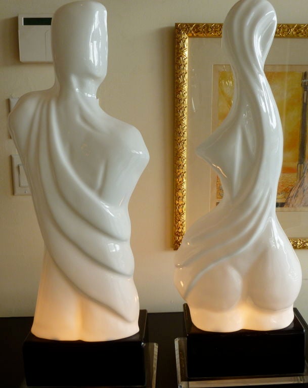 White opague lucite body meets black opague lucite base; these are very 80's and sensual.... with their exposed back..and draped front... great for nightstands against a wall. Great luminosity on the bottom portion.the black lucite base sits on a