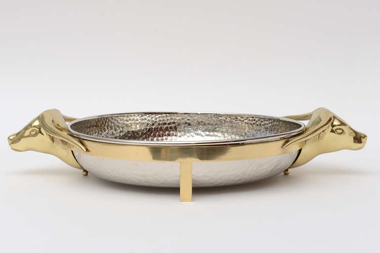 This delightful two part centerpiece or coffee table bowl is hand-hammered nickel silver and polished brass.
The hand-hammered silver piece fits into the brass outer part. The Texas longhorn appendages are conversational!!! It has all been