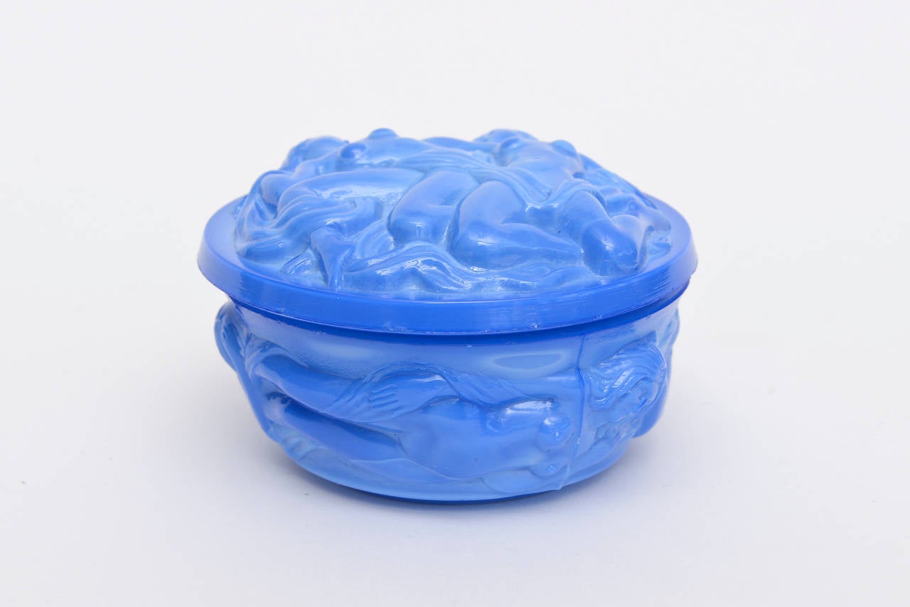 Lovely female nude sensual forms forms cascade on the glass box everywhere. The color is a gorgeous rich periwinkle/sea blue. It is a two part round box.
The nude female forms are raised and textural.
It is period.