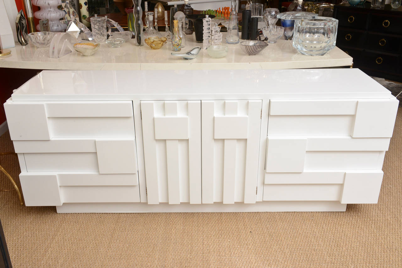 This wonderful newly white lacquered dresser/cabinet from the 1950s has fronts of cubist  and Louise Nevelson inspired influences that give its sculptural forms.
The wood has dimensional juts of depth and form.
It has been newly white lacquered
