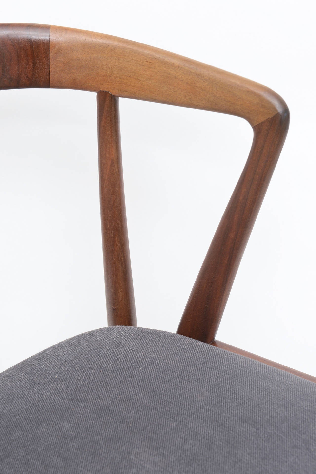 This sculptural matchbook walnut and mahogany side or desk chair is handsome.
This was in the style and influence of Gio Ponti done by Bertha Schaeffer
The new upholstery in gray fabric is very manly!
It has great form from all angles. The seat