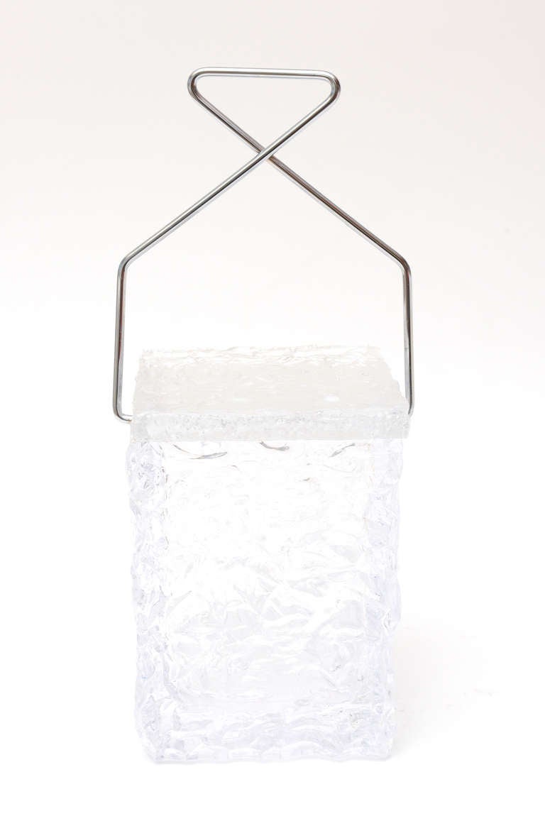 This tongue in cheek square ice bucket is in the shape and texture of an ice cube with chrome ice tongs as the handles. Artful!!!
it is stamped Wilardy on the handle.
The height of the cube alone is 9