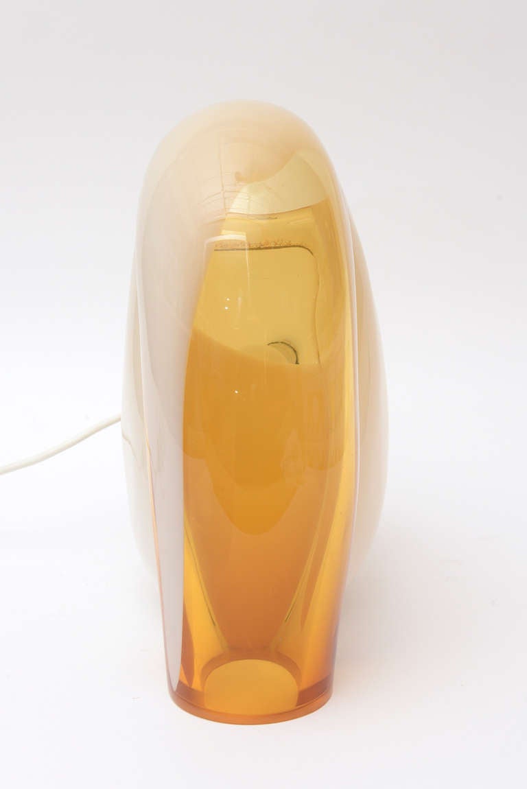 This vintage Murano Italian Vistosi sculptural glass lamp is sculptural and in the shape of a snail or an abstract design. The crème to off-white color of the body and the yellowy amber peak lend to great contrast. This Italian Murano table lamp has