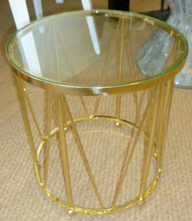 The greatness of this polished brass vintage drum table is that it stands alone as a side and or end table. It has good weight to it and a fabulous look, very sculptural and timeless. The top is glass. There is only one of these and perfect between